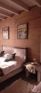 1 dormitorio con cama y banco. en Jardines del Este en San Carlos de Bariloche