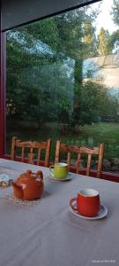 una mesa con tres tazas y platos en ella en Jardines del Este en San Carlos de Bariloche