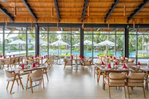 a restaurant with tables and chairs and a pool at Rosa Alba Resort & Villas Tuy Hoa in Tuy Hoa