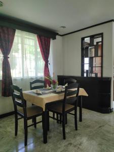 Tropical Paradise Retirement Village Inc في Sawat: غرفة طعام مع طاولة وكراسي ومرآة