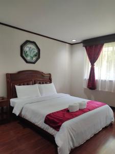 a bedroom with a large bed with two towels on it at Tropical Paradise Retirement Village Inc in Sawat