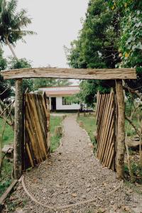 um portão de madeira com um caminho que leva a uma casa em VayalMonk - Alleppey Island Isolated Villa resort em Alappuzha