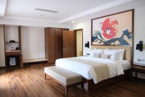 a bedroom with a large white bed and a painting at Bang Onsen Spa & Resort in Bang +49 photos