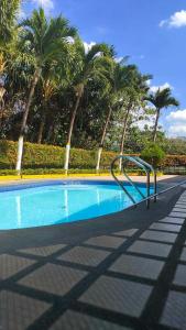 een leeg zwembad met palmbomen op de achtergrond bij Tropical Paradise Retirement Village Inc in Sawat