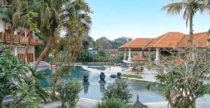 een zwembad in een resort met een fontein en palmbomen bij Novus Giri Resort & Spa in Puncak