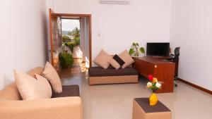 a living room with two couches and a television at EXCLUSIVE CONDO GALAPAGOS and BEYOND 1 in Puerto Ayora