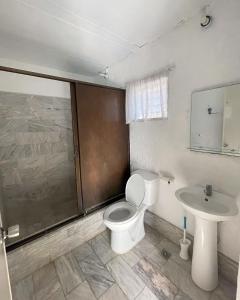a bathroom with a toilet and a sink at Beach Road Apartments in Matabungkay