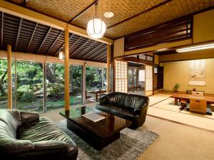 sala de estar con sofá de cuero y mesa en Hoshi, en Komatsu