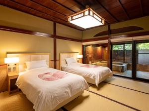 a bedroom with two beds and a large window at Hoshi in Komatsu