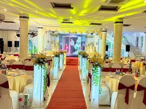 a banquet hall with white tables and chairs and flowers at Hung Vuong Hotel in Tuy Hoa