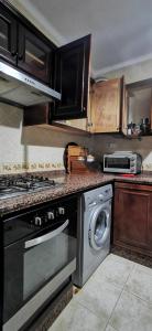 een keuken met een fornuis en een wasmachine bij Sania Plage,Marina Smir in Marina Smir