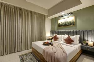 una camera da letto con un grande letto con lenzuola bianche di Saltstayz Premier - Golf Course Extension Road a Gurgaon