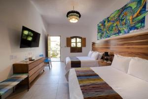 a hotel room with two beds and a desk at NaNa Vida Hotel Oaxaca in Oaxaca City
