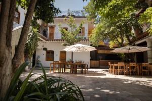 un patio con mesas y sombrillas frente a un edificio en NaNa Vida Hotel Oaxaca, en Oaxaca City