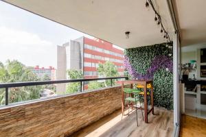 een balkon met een houten tafel en een groot raam bij Habitación c/baño independiente, a unos min del Centro Histórico in Mexico-Stad