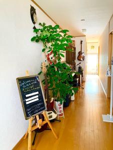 金沢市にあるゲストハウス西金沢Smile&smileの植物とチョークボードとギターを備えた部屋