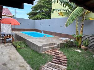 a person swimming in a swimming pool in a backyard at Casa 4 quartos com piscina Grussai in São João da Barra