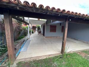 a building with a tile walkway with a roof at Casa 4 quartos com piscina Grussai in São João da Barra