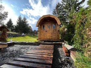 een kleine houten hut met een houten loopbrug in een tuin bij BERGLAGE - Das UrlaubZuhause in Braunlage