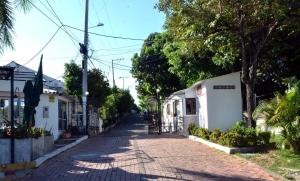 Une rue vide dans une petite ville arborée dans l'établissement Casa Vacacional con Jacuzzi en Girardot Cundinamarca, à Girardot