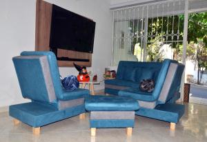 - un salon avec 2 chaises bleues et une télévision dans l'établissement Casa Vacacional con Jacuzzi en Girardot Cundinamarca, à Girardot