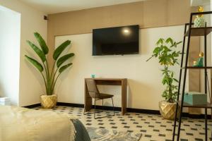 een slaapkamer met een bureau en een tv aan de muur bij Polanco - Suite 2 de Lujo en Nápoles Cama King Size in Mexico-Stad