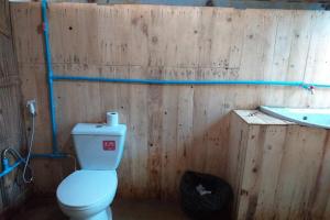 ein Holzbadezimmer mit einem WC und einer Badewanne in der Unterkunft Doi PuMuen LAHU Homestay in Ban Wiang Kok