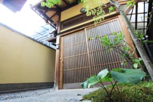 an entrance to a building with a wooden gate at Our-Turn Traditional Machiya near Heian Shrine in Kyoto +22 photos