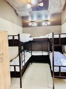 a room with three bunk beds in a room at Like Home Hostel na Shevchenko, 162Б in Almaty