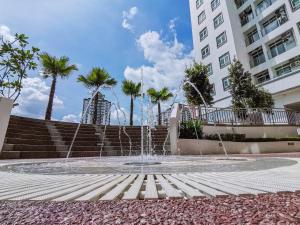 a fountain in front of a building with palm trees at Titiwangsa Monorail MRT WTC HKL KLCC IJM Cozy Place A2811 in Kuala Lumpur