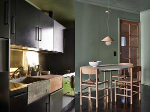 a kitchen with a table and some chairs in it at Ross Farm - Cabin in Meeniyan