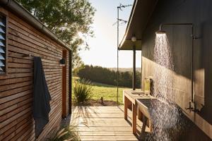 a bathroom with a shower on the side of a building at Ross Farm - Cabin in Meeniyan