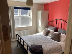 um quarto com uma cama com uma parede vermelha em City living apartment no3 em Bristol
