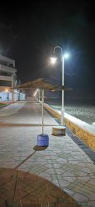 een parasol op een stoep bij het strand 's nachts bij Sania Plage,Marina Smir in Marina Smir