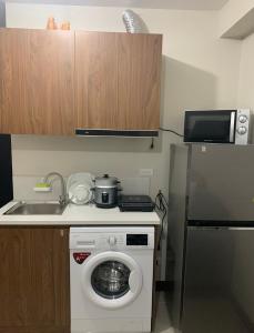 a small kitchen with a washing machine and a sink at Saekyung village one phase 3 in Suba