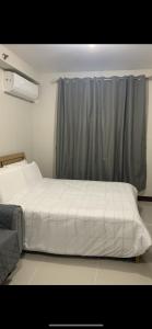 a bedroom with a large white bed and a window at Saekyung village one phase 3 in Suba
