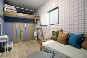 a room with a bunk bed and a couch at LARK OKUBO Free wifi in Tokyo