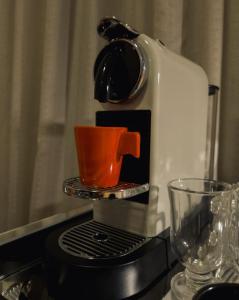a coffee maker with an orange cup on a stove at The Best Deluxe - Duplex Studio - Hotel Slav Moema - by LuXXoR in Sao Paulo