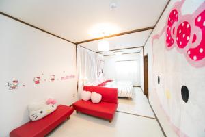 - une chambre avec une chaise rouge et un lit dans l'établissement 7 min to JR Yokkaichi STN Large House - Vacation STAY 14161, à Yokkaichi