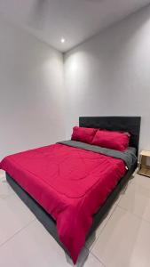 łóżko z czerwoną kołdrą w białym pokoju w obiekcie KLIA SomeHouse Homestay w mieście Banting