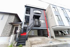un immeuble d'appartements avec un escalier dans un parking dans l'établissement 7 min to JR Yokkaichi STN Large House - Vacation STAY 14161, à Yokkaichi