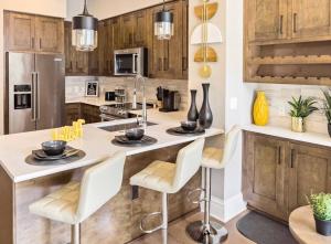 a kitchen with wooden cabinets and a large island with chairs at Serenity In The City in Atlanta