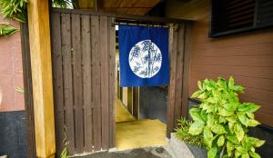 a flag is hanging on the door of a house at Kamegawa Onsen HATAGO Yuyu in Beppu