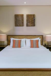 a bedroom with a large white bed with two lamps at Balai Adlao in El Nido