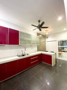 uma cozinha com armários vermelhos e uma ventoinha de tecto em CozyHouse 4ROOM 4BATH ROOM 8PAX@Near BM Icon city em Bukit Mertajam