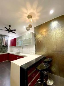 uma cozinha com armários vermelhos e uma ventoinha de tecto em CozyHouse 4ROOM 4BATH ROOM 8PAX@Near BM Icon city em Bukit Mertajam