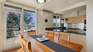 a kitchen with a wooden table and a large window at Nakarra in Lake Tyers
