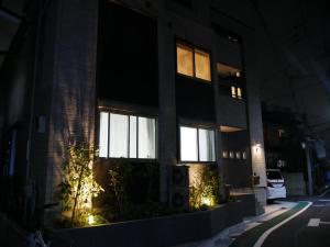 東京にある幸町HOUSEの窓に照明を灯す夜の建物