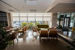 een restaurant met een bank en tafels en stoelen bij Hotel Dastan Aktobe in Aqtöbe