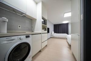 麗水的住宿－Myeongga Ubleth Hotel，客房内的厨房配有洗衣机